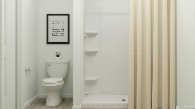 bathroom with hardwood / wood-style floors, toilet, and walk in shower