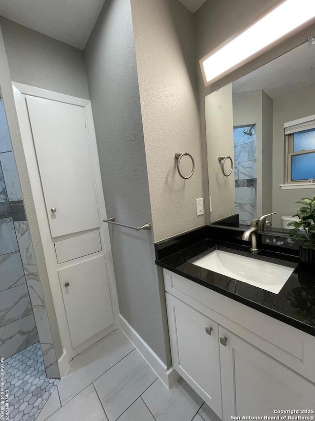 bathroom with vanity and tiled shower