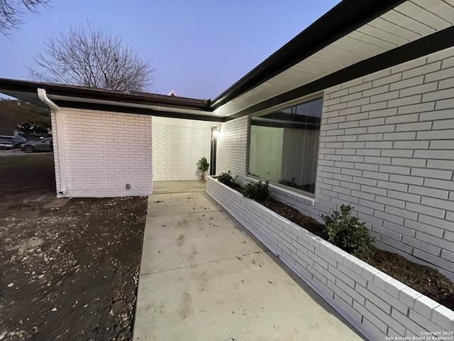 property exterior at dusk with a patio area