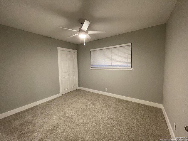 carpeted empty room featuring ceiling fan