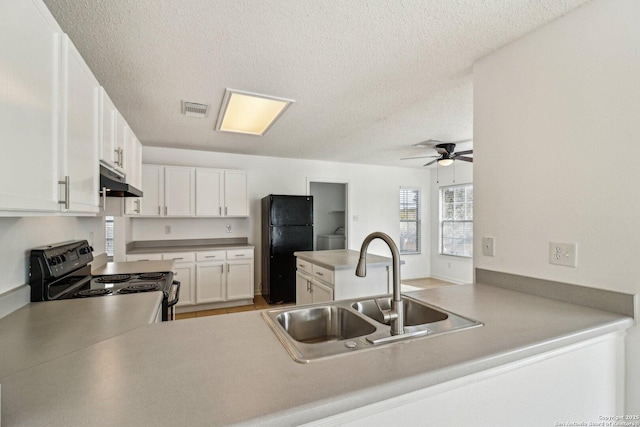 kitchen with black appliances, sink, white cabinets, kitchen peninsula, and a textured ceiling