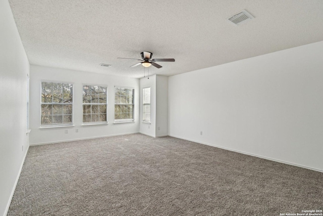 carpeted spare room featuring a textured ceiling and ceiling fan