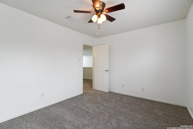 unfurnished room with ceiling fan and dark colored carpet