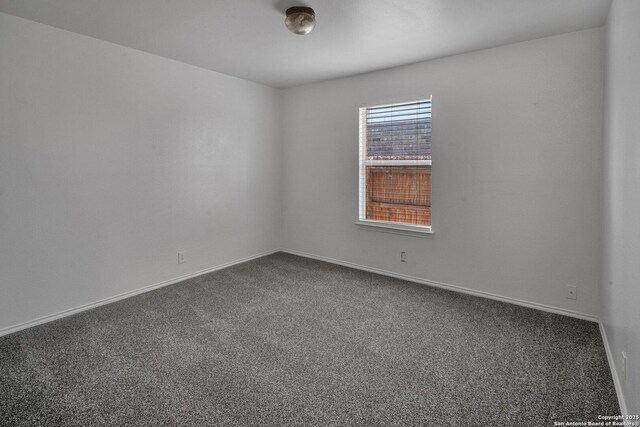 empty room featuring dark carpet