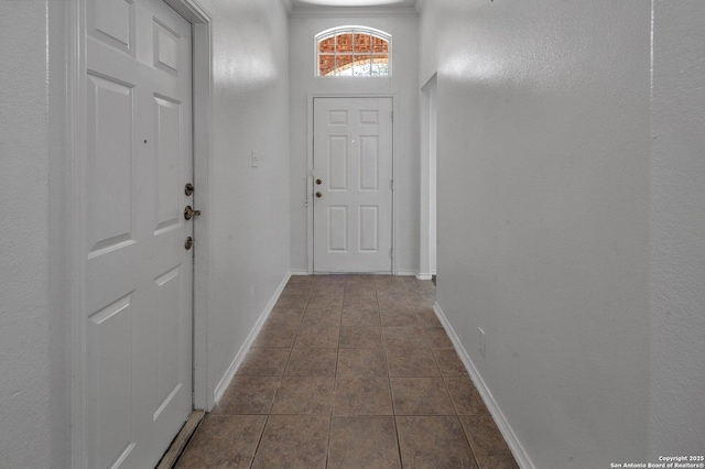 doorway to outside featuring dark tile patterned flooring