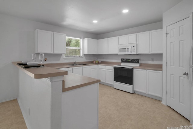 kitchen with white cabinetry, sink, white appliances, and kitchen peninsula