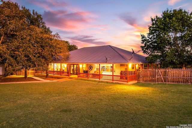 back house at dusk featuring a yard