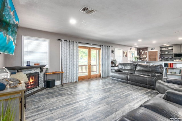 living room with french doors, a fireplace, and hardwood / wood-style floors