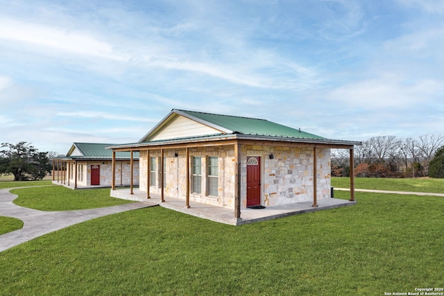 rear view of property featuring a lawn and a patio area