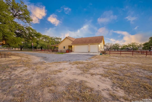 view of front of property with a garage and a rural view