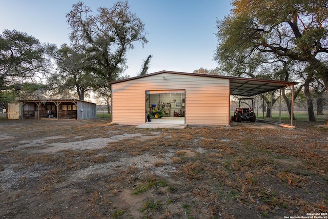 outdoor structure at dusk featuring a carport