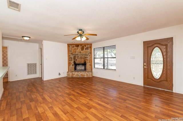 unfurnished living room featuring ceiling fan, a fireplace, hardwood / wood-style floors, and a textured ceiling