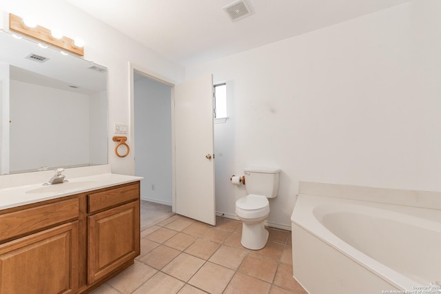 bathroom featuring vanity, a tub, tile patterned floors, and toilet