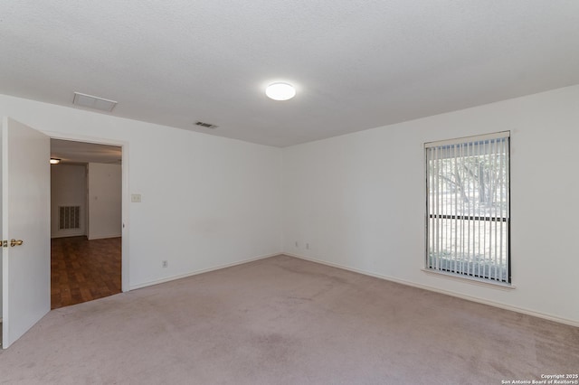 carpeted empty room with a textured ceiling