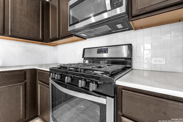 kitchen with tasteful backsplash, dark brown cabinetry, stainless steel appliances, and light stone counters