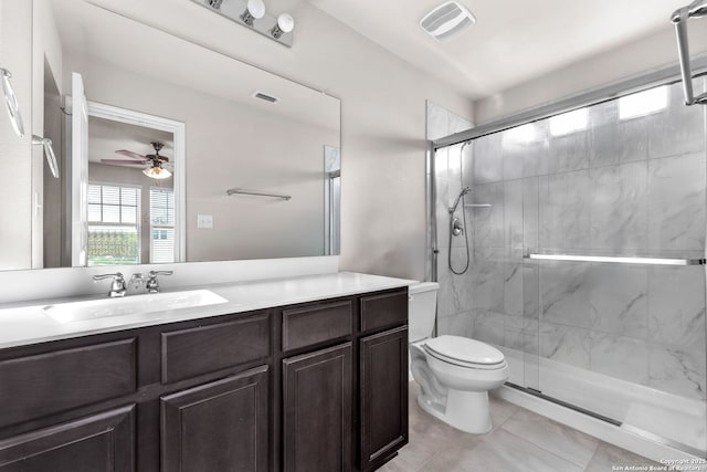 bathroom with a shower with door, vanity, ceiling fan, and toilet