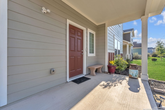 entrance to property with a lawn and a patio