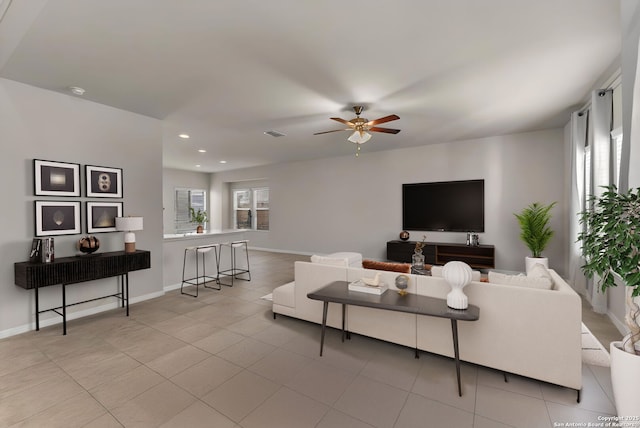 living room with ceiling fan, plenty of natural light, and light tile patterned floors