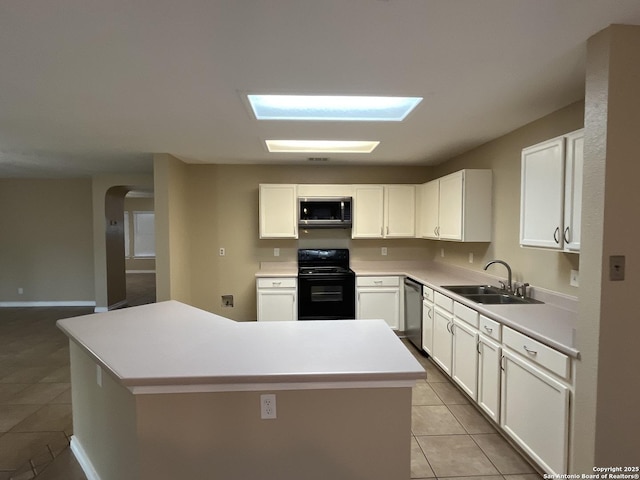 kitchen featuring sink, light tile patterned floors, appliances with stainless steel finishes, white cabinetry, and a kitchen island