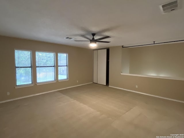 unfurnished room featuring ceiling fan and light carpet