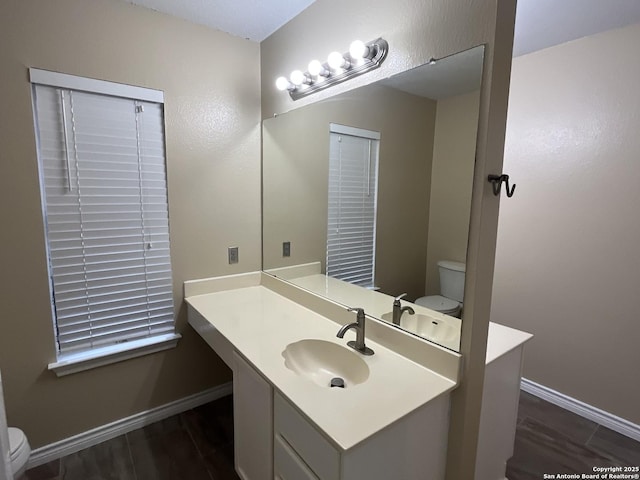 bathroom featuring vanity, wood-type flooring, and toilet