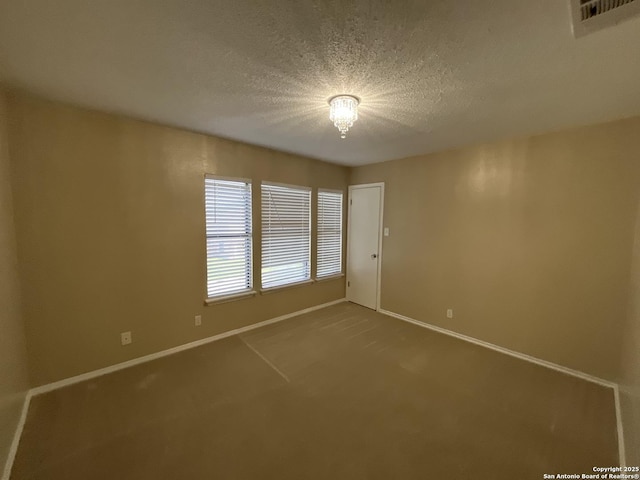 unfurnished room featuring carpet and a textured ceiling