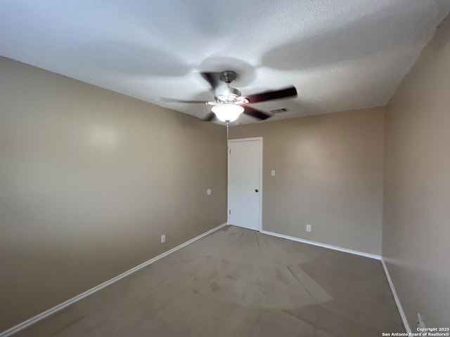 unfurnished room with ceiling fan and a textured ceiling