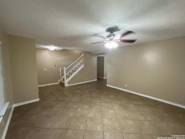 tiled spare room featuring a textured ceiling and ceiling fan