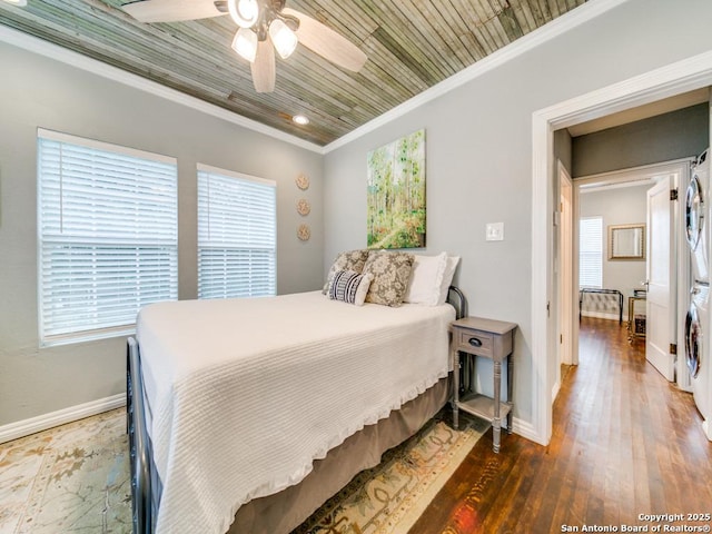 bedroom with stacked washer and clothes dryer, crown molding, wood ceiling, dark hardwood / wood-style floors, and ceiling fan