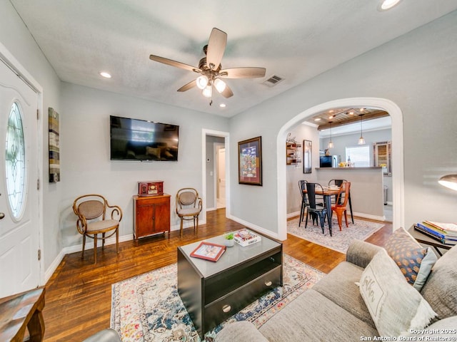 living room with dark hardwood / wood-style flooring and ceiling fan