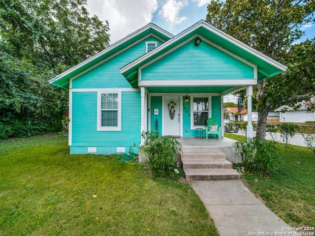 bungalow-style home with covered porch and a front lawn