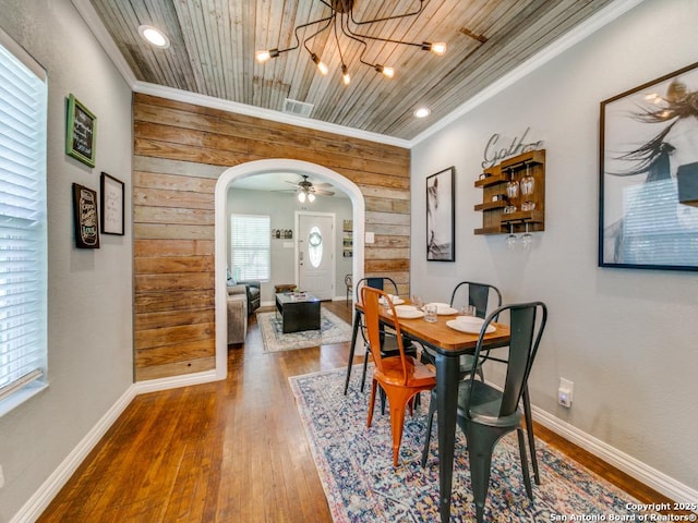 dining room with wood-type flooring, wooden ceiling, and crown molding