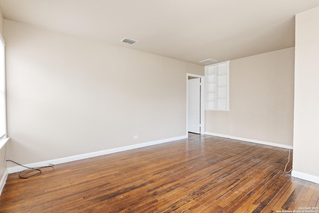 empty room with dark hardwood / wood-style flooring