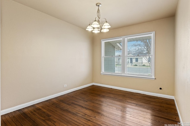 unfurnished room with hardwood / wood-style flooring and a chandelier