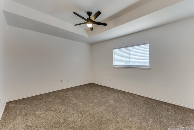 carpeted empty room featuring ceiling fan and a tray ceiling