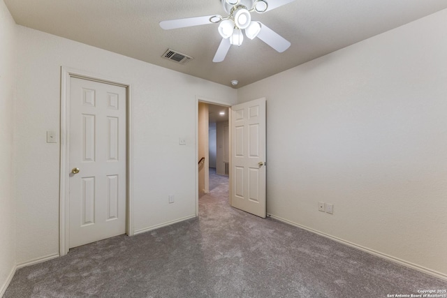 unfurnished bedroom featuring ceiling fan and dark carpet