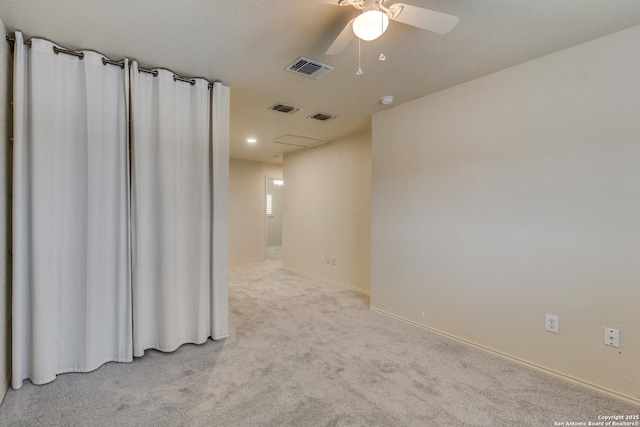 empty room featuring ceiling fan and light colored carpet