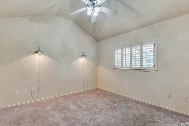 carpeted empty room with ceiling fan and vaulted ceiling