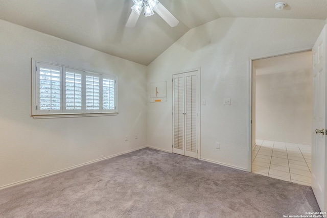 spare room featuring lofted ceiling, light colored carpet, and ceiling fan