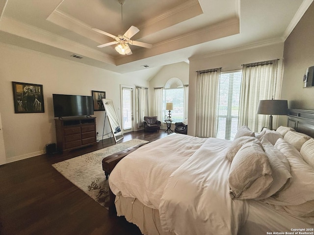 bedroom with dark wood-type flooring, ceiling fan, ornamental molding, and a raised ceiling