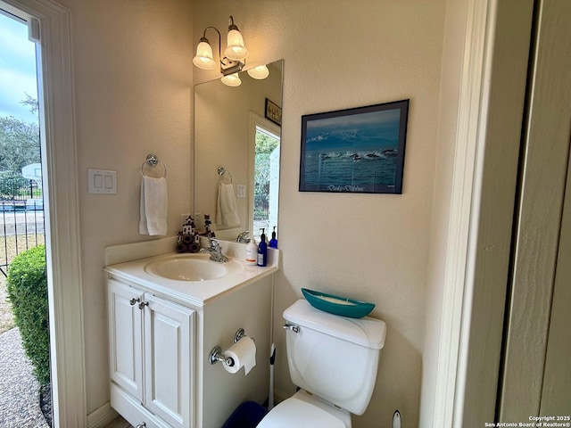 bathroom featuring vanity, an inviting chandelier, and toilet