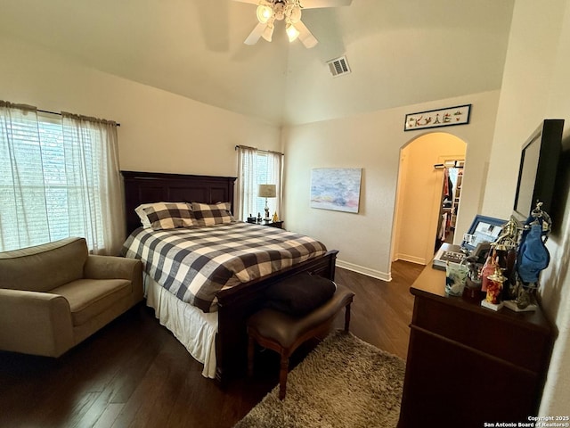 bedroom with dark hardwood / wood-style flooring, a spacious closet, vaulted ceiling, and ceiling fan