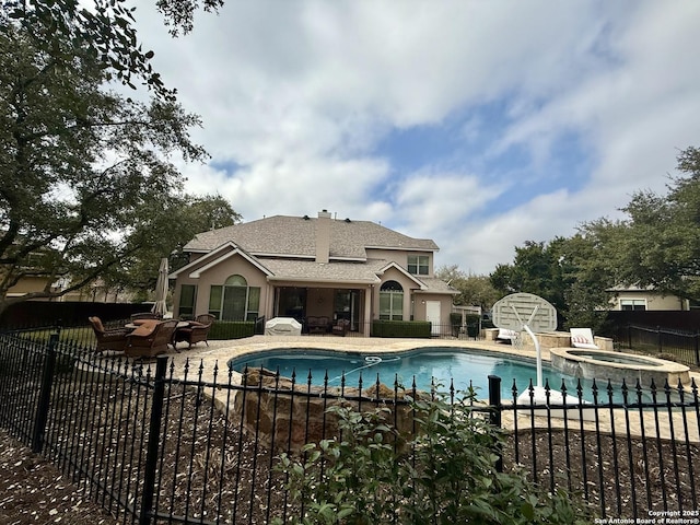 view of pool with an in ground hot tub and a patio