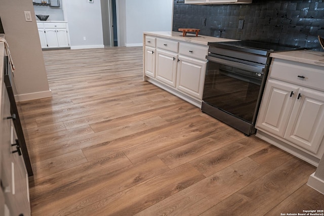 kitchen with range with electric cooktop, light wood-type flooring, decorative backsplash, and white cabinets