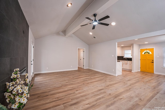 unfurnished living room with ceiling fan, vaulted ceiling with beams, sink, and light hardwood / wood-style floors