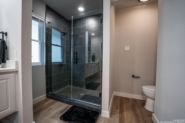 bathroom with vanity, wood-type flooring, a shower with door, and toilet