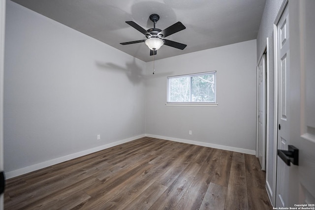 unfurnished room with dark wood-type flooring and ceiling fan