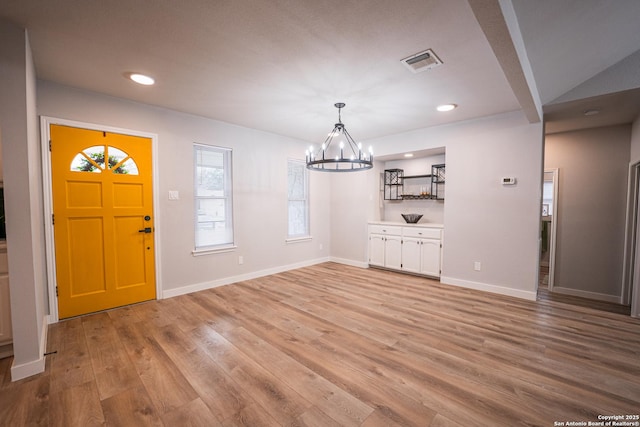 interior space featuring an inviting chandelier and light wood-type flooring