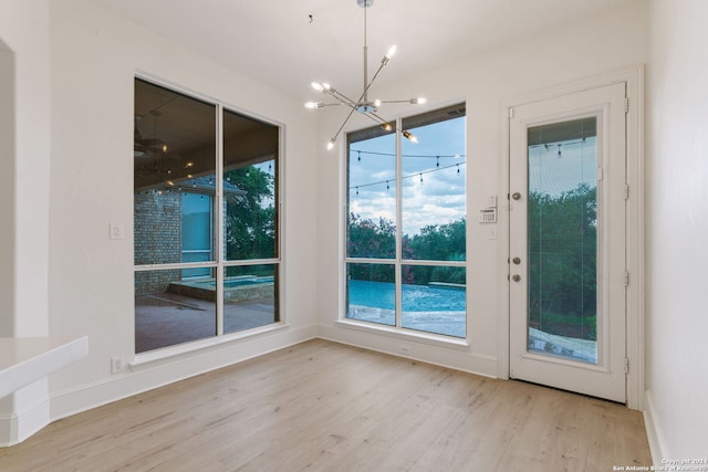 interior space with an inviting chandelier and light hardwood / wood-style floors