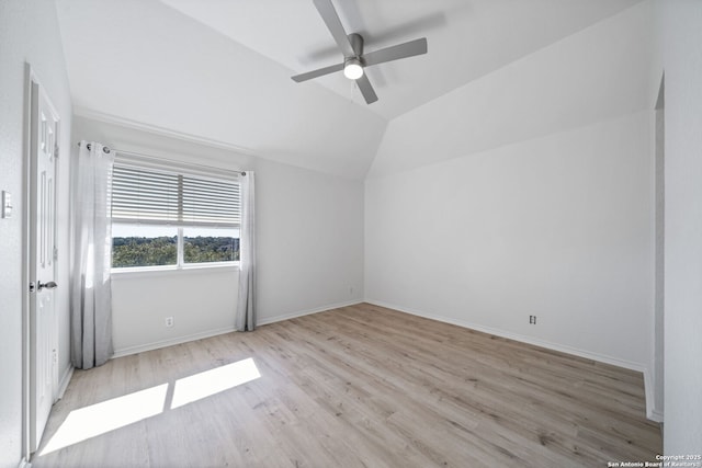 empty room featuring vaulted ceiling, ceiling fan, and light wood-type flooring